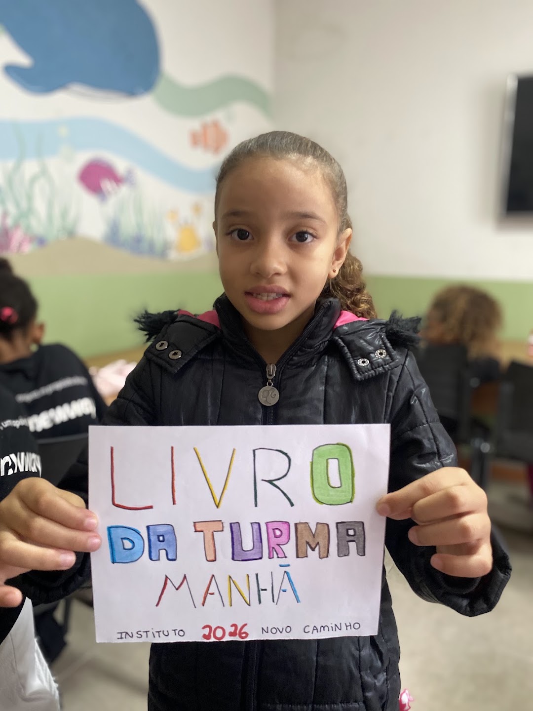 Criança apresentando o Livro da turma